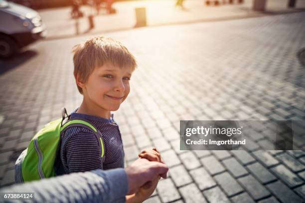 wandelen zoon naar school - zebrapad stockfoto's en -beelden