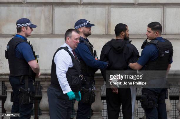 Man is detained by police officers near Downing Street, on Whitehall on April 27, 2017 in London, England. Multiple knives were seen at the scene...