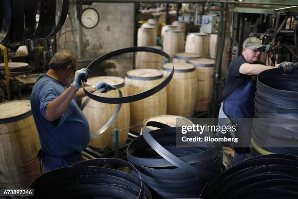 Factory workers install hoops onto white oak bourbon barrels at the Brown-Forman Corp. Cooperage facility in Louisville, Kentucky, U.S., on Thursday,...