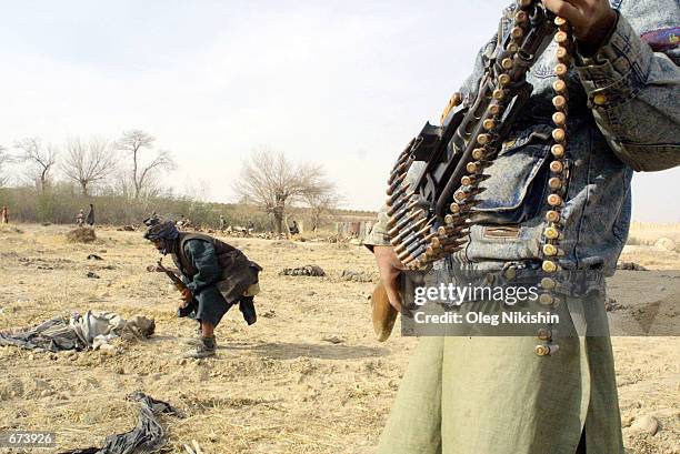 Northern Alliance fighter checks the dead body of a pro-Taliban soldier November 28, 2001 in the fortress prison near Mazar-e-Sharif, Afghanistan....