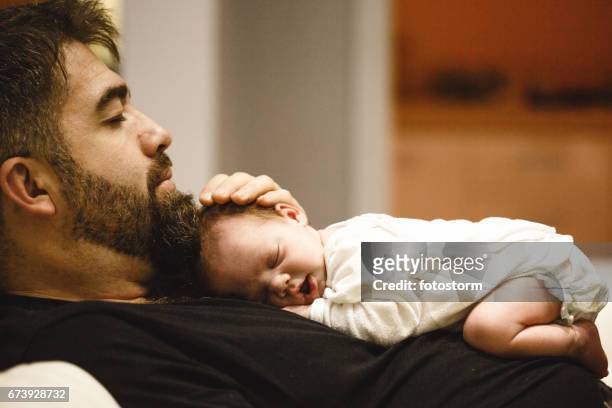father holding a sleeping newborn baby - baby father hug side stock pictures, royalty-free photos & images