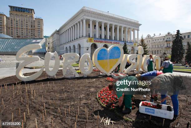 Communal workers plant flowers in front of a decorative the Eurovision Song Contest 2017 logo, during the preparations on Independence Square in...