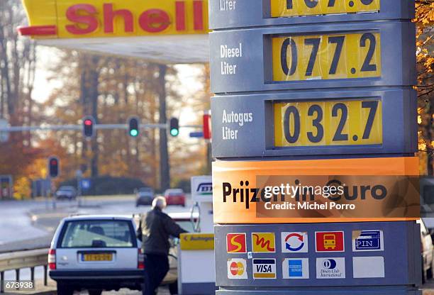 Sign displays gas prices in the Euro currency as customers pump gas into their vehicles November 28, 2001 in Dieren, The Netherlands. Many major fuel...