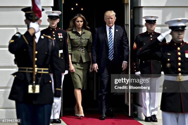 President Donald Trump, right, and U.S. First Lady Melania Trump walk out of the South Portico of the White House to greet Mauricio Macri,...