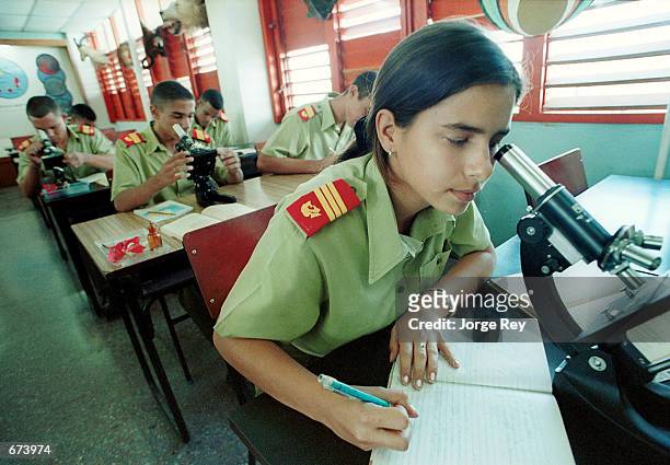 Yumara Borges and other students look through microscopes as they study at a laboratory November 26, 2001 at the School of the Army "Camilo...