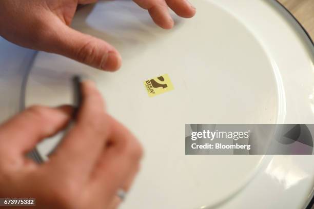 An employee places a logo on the back of a pewter plate at the Baro Industrial SA manufacturing facility in the Azcapotzalco neighborhood of Mexico...