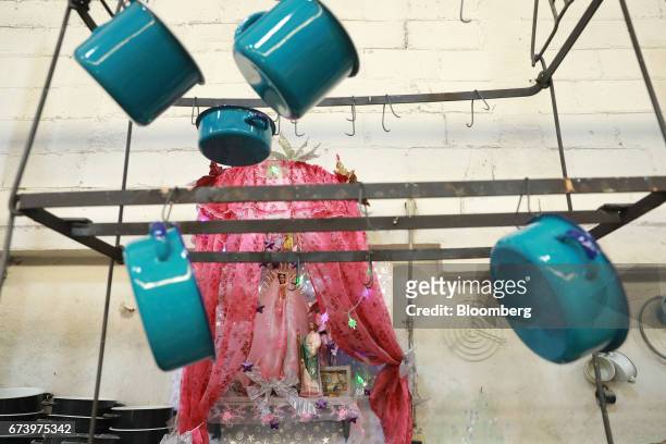 Enameled pewter cookware hang on a rack at the Baro Industrial SA manufacturing facility in the Azcapotzalco neighborhood of Mexico City, Mexico, on...