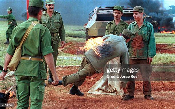 Cuban soldiers learn how to extinguish a fire on their person November 27, 2001 at an armored unit base 25 kilometers west of Havana. The Armed...