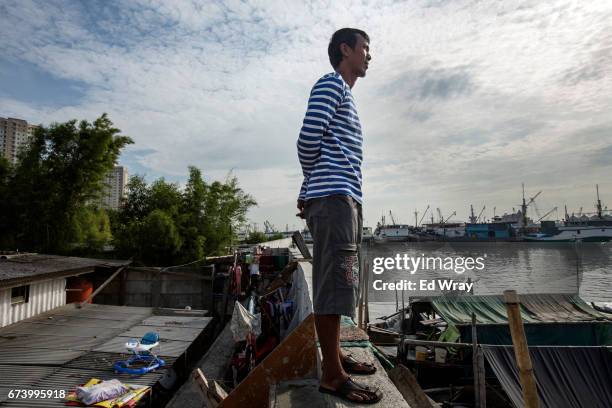 Young man looks out from atop a newly built section of seawall on April 27, 2017 in Jakarta, Indonesia. Jakarta, one of the world's most densely...