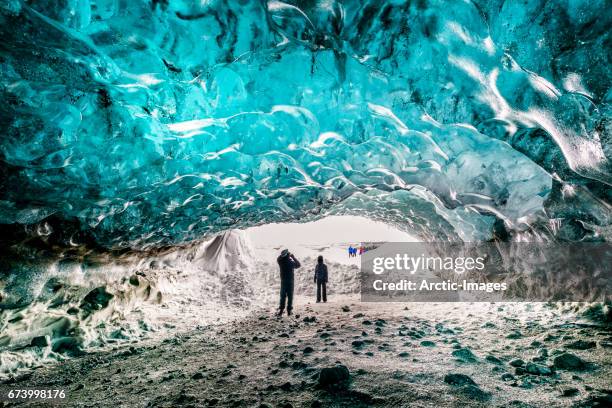 tourists in the crystal cave, breidamerkurjokull glacier, iceland - crystal caves stock-fotos und bilder