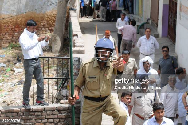 Forest guard controls the people after a leopard entered a house in Durga Colony of Sohna locality, on April 27, 2017 some 25 km from Gurgaon, India.