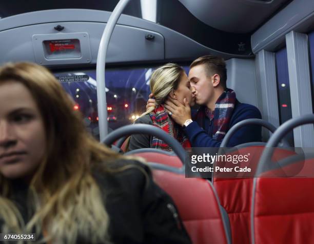 Young couple kissing at back of bus