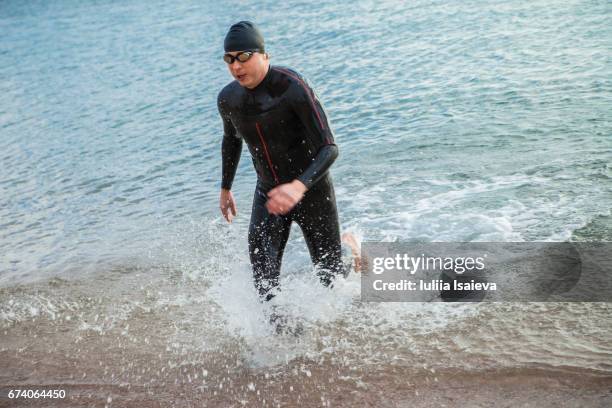 diver walking out of water - wetsuit stock pictures, royalty-free photos & images