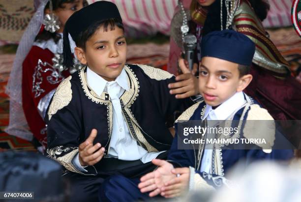 Libyan boys dressed in traditional outfits attend a school event in the Tajoura area in the capital Tripoli on April 2017. / AFP PHOTO / MAHMUD TURKIA