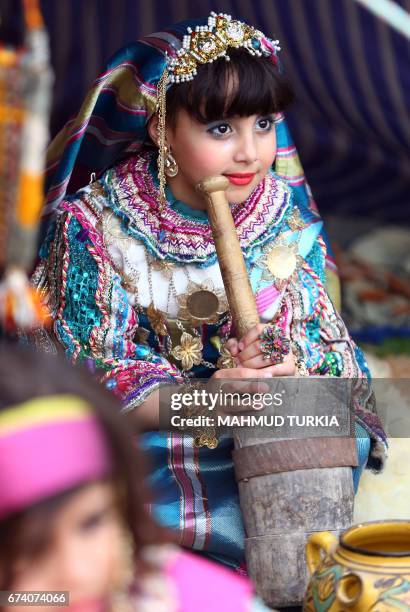 Libyan girl dressed in traditional outfit looks on during a school event in the Tajoura area in the capital Tripoli on April 2017. / AFP PHOTO /...