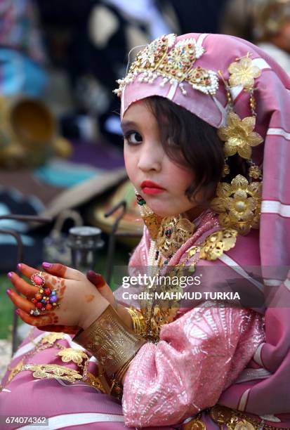 Libyan girl dressed in traditional outfit looks on during a school event in the Tajoura area in the capital Tripoli on April 2017. / AFP PHOTO /...