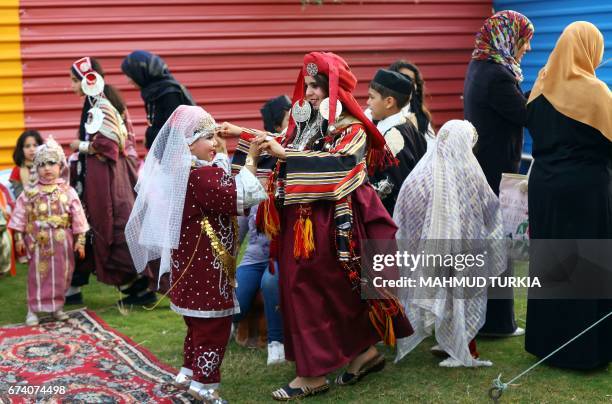 Libyan children dressed in traditional outfits play during a school event in the Tajoura area in the capital Tripoli on April 2017. / AFP PHOTO /...