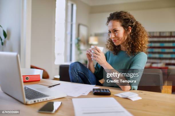 single, vrouw thuis met technologie. - belastingen stockfoto's en -beelden