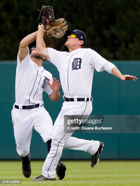 Right fielder Jim Adduci of the Detroit Tigers beats center fielder Tyler Collins of the Detroit Tigers to a fly ball hit by Nelson Cruz of the...