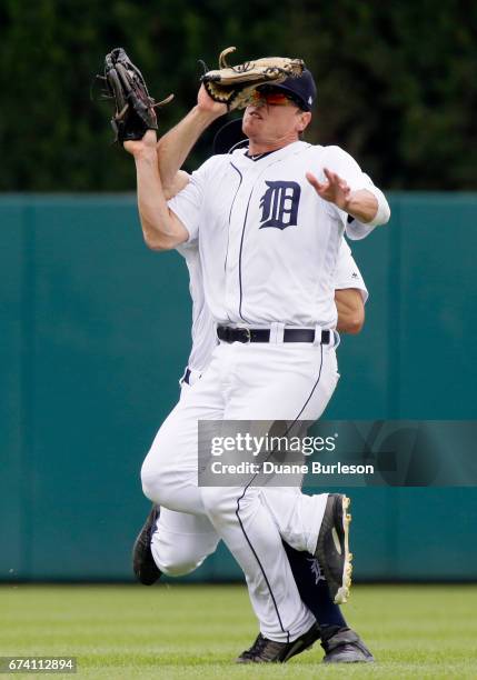 Right fielder Jim Adduci of the Detroit Tigers, front, collides with center fielder Tyler Collins of the Detroit Tigers after getting a fly ball hit...