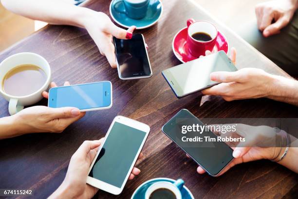 friends at table with circle of smartphones - five friends unity stock pictures, royalty-free photos & images