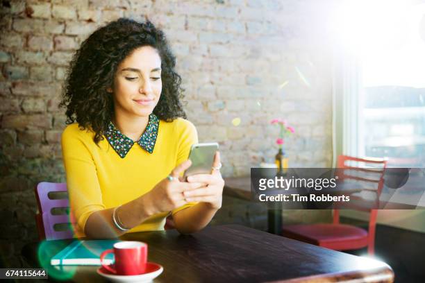 woman using mobile in coffee shop - bistro stock pictures, royalty-free photos & images