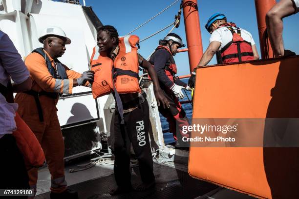 Just after having been rescued from a rubber boat in distress, a woman cries while setting foot on board the Aquarius on March 3rd 2017. Pushed by...
