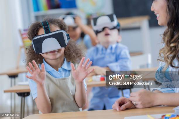 happy girl uses virtual reality goggles at school - virtual reality classroom stock pictures, royalty-free photos & images