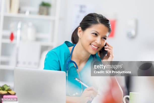 happy nurse on the phone with a patient - beautiful filipino women stock pictures, royalty-free photos & images