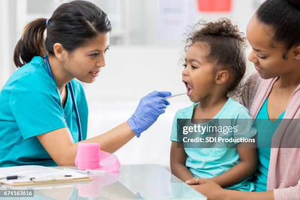 kinderarzt untersucht junge patienten - notfallmedizin stock-fotos und bilder