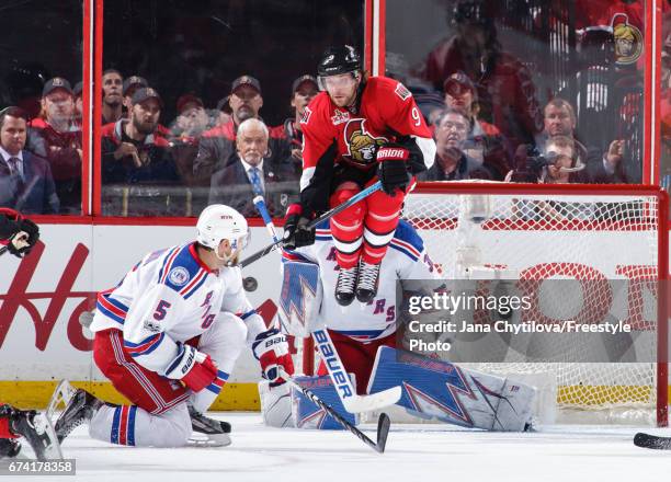 Bobby Ryan of the Ottawa Senators jumps as the puck is shot and Henrik Lundqvist of the New York Rangers makes a save and Dan Girardi of the New York...