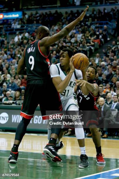 Serge Ibaka and Kyle Lowry of the Toronto Raptors guard against John Henson of the Milwaukee Bucks in the second quarter in Game Six of the Eastern...