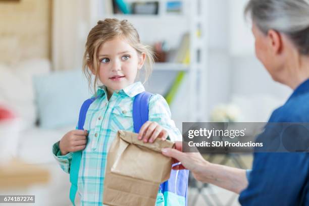 grandma gives granddaughter a sack lunch - lunch bag stock pictures, royalty-free photos & images