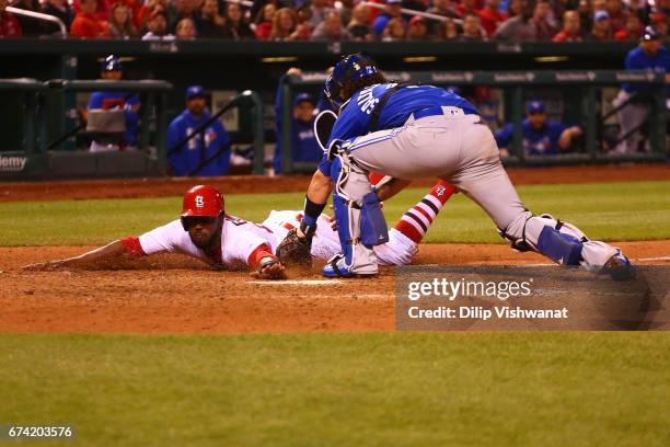 Dexter Fowler of the St. Louis Cardinals is tagged out at home plate by Jarrod Saltalamacchia of the Toronto Blue Jays in the eighth inning at Busch...