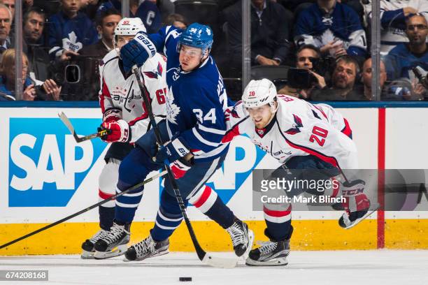 Auston Matthews of the Toronto Maple Leafs skates against Lars Eller and Andre Burakovsky of the Washington Capitals during the first period in Game...
