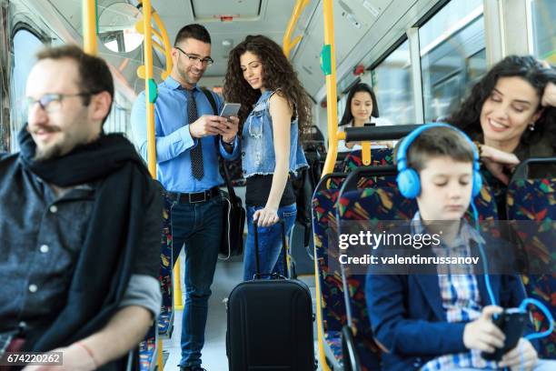 junges paar reisen und mit smartphone - bus innen stock-fotos und bilder