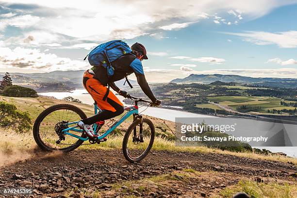 mountain bikers ride along columbia river. - mountainbiken fietsen stockfoto's en -beelden