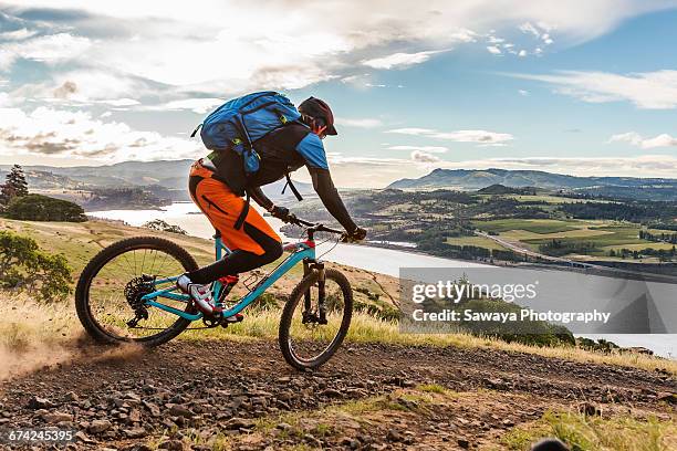 mountain bikers ride along columbia river. - sawaya stock pictures, royalty-free photos & images