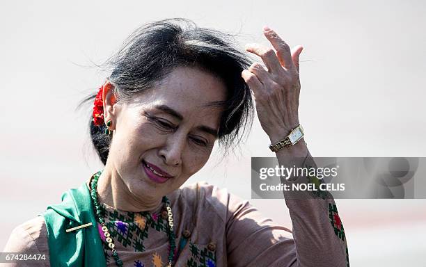 Myanmar's State Counsellor and Foreign Minister Aung San Suu Kyi gestures upon her arrival at Manila's international airport on April 28, 2017 to...