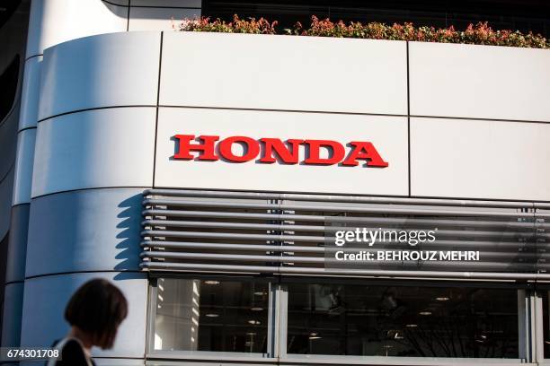 Woman walks past the Honda headquarters building in Tokyo on April 28, 2017. Honda on April 28 said its annual net profit jumped 79 percent on a...