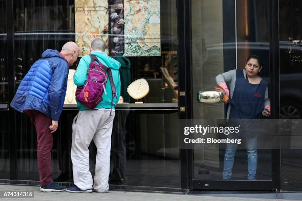 Cleaner polishes the door handle of a luxury jewelery store on Bond Street in London, U.K., on Thursday, April 27, 2017. LVMH Moet Hennessy Louis...