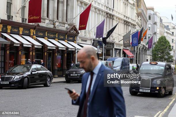 Pedestrian passes a row of luxury retail stores on New Bond Street in London, U.K., on Thursday, April 27, 2017. LVMH Moet Hennessy Louis Vuitton...