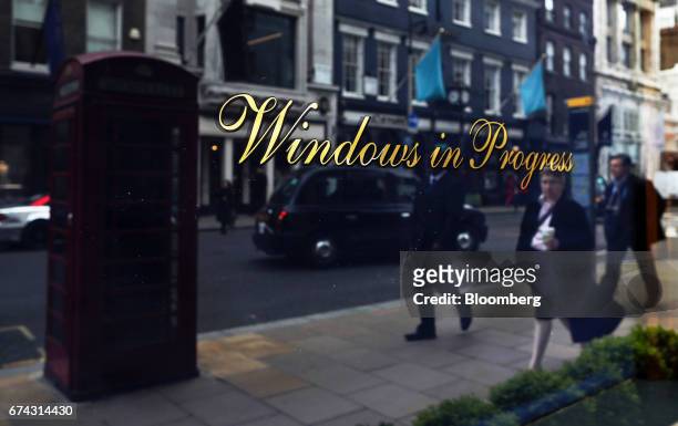 Pedestrians are reflected in the window of a Ralph Lauren Corp. Store on New Bond Street in London, U.K., on Thursday, April 27, 2017. LVMH Moet...