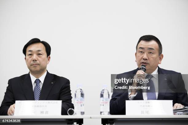 Masaki Yamauchi, president of Yamato Holdings Co., left, listens as Yutaka Nagao, president of Yamato Transport Co., speaks during a news conference...