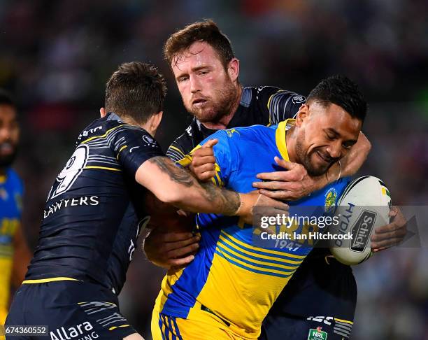 Kenneth Edwards of the Eels is tackled by Gavin Cooper and Benjamin Hampton of the Cowboys during the round nine NRL match between the North...