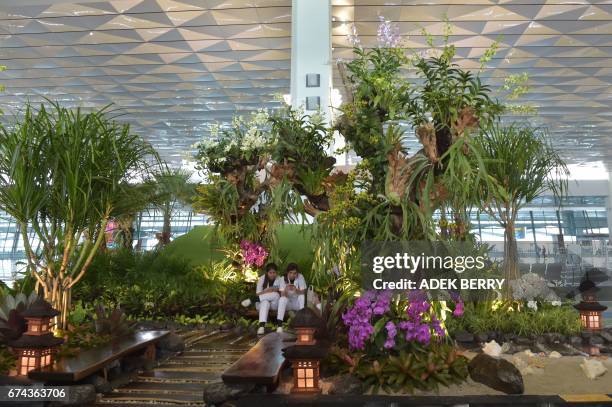 Employees take a rest inside Terminal 3 of the Soekarno-Hatta airport in Tangerang, on the outskirts of Jakarta on April 28, 2017. National flag...