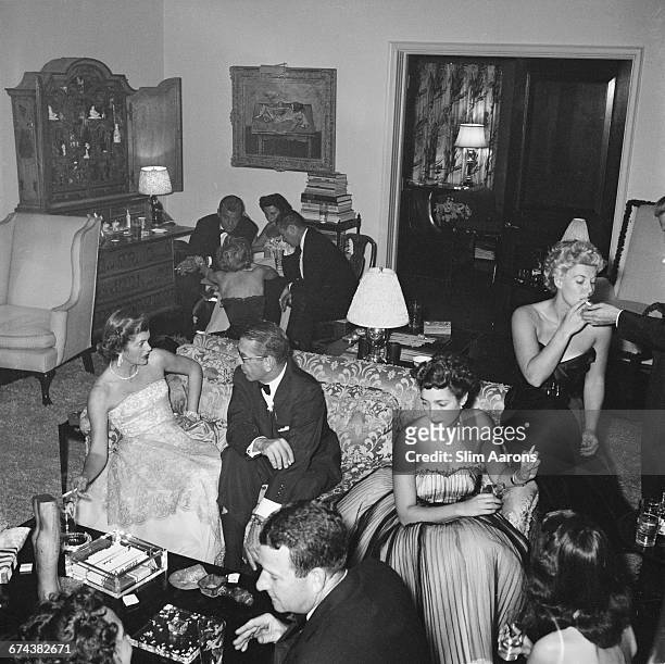 Guests at a party given by Mrs Gary Cooper in Beverly Hills, California, 1952. She is on the left, seated on the couch with Mr Van Herbick and Jack...