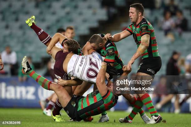 Martin Taupau of the Sea Eagles is tackled by Cameron Murray, Robbie Farrah and Sam Burgess of the Rabbitohs during the round nine NRL match between...