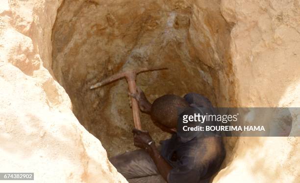 Man digs in a hole as hundreds of people search gold on April 25, 2017 in Kafa-Koira, south of Niamey. Hundreds of people, sometimes whole families,...