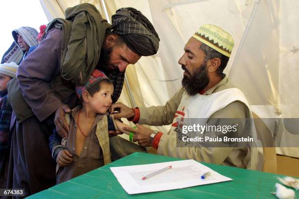 Medecins Sans Frontieres worker examines an Afghan refugee child November 29, 2001 at the Chaman refugee camp on the Pakistani border with...